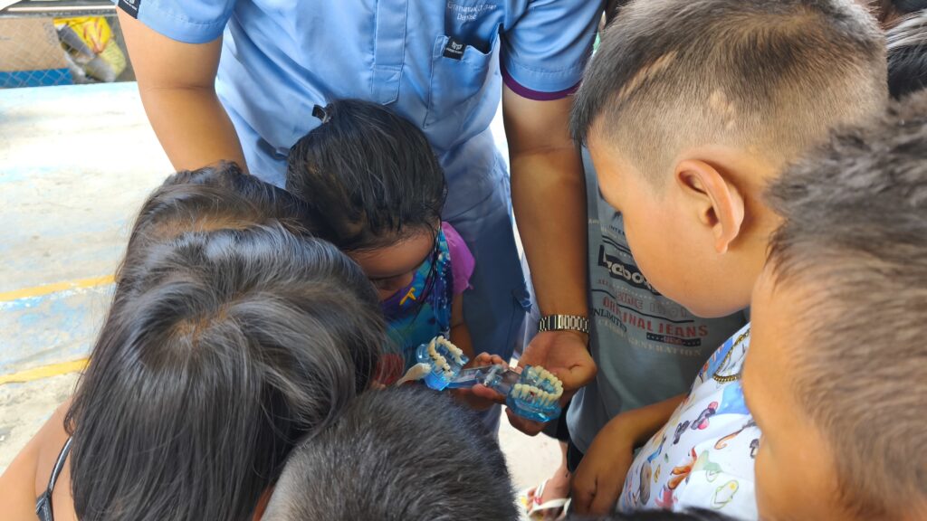 Ocean Smiles Dental Clinic teaches proper tooth-brushing techniques to young learners.